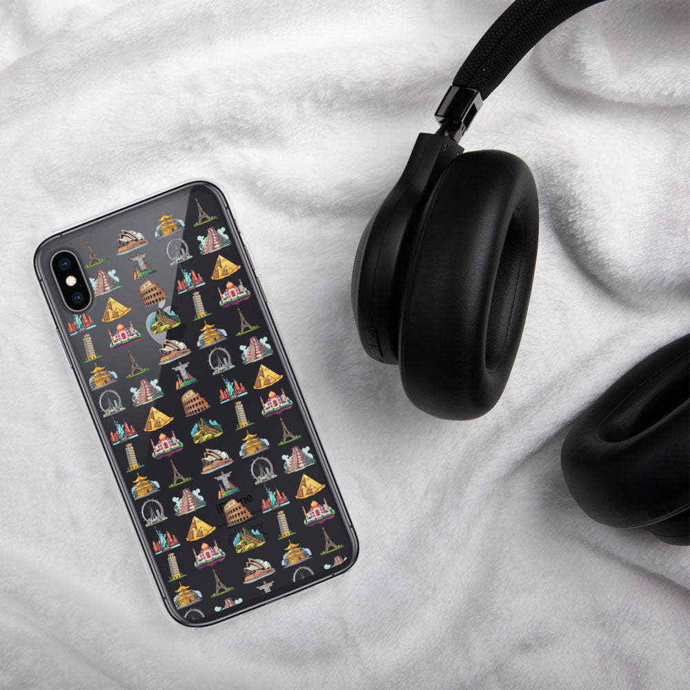 black iPhone with a case featuring famous travel landmarks on a white linen background with a black headphone