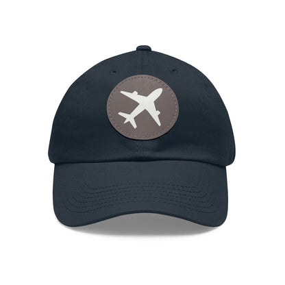 Chic navy twill cotton baseball cap with a round gray leather patch showcasing an airplane emblem, on a white background