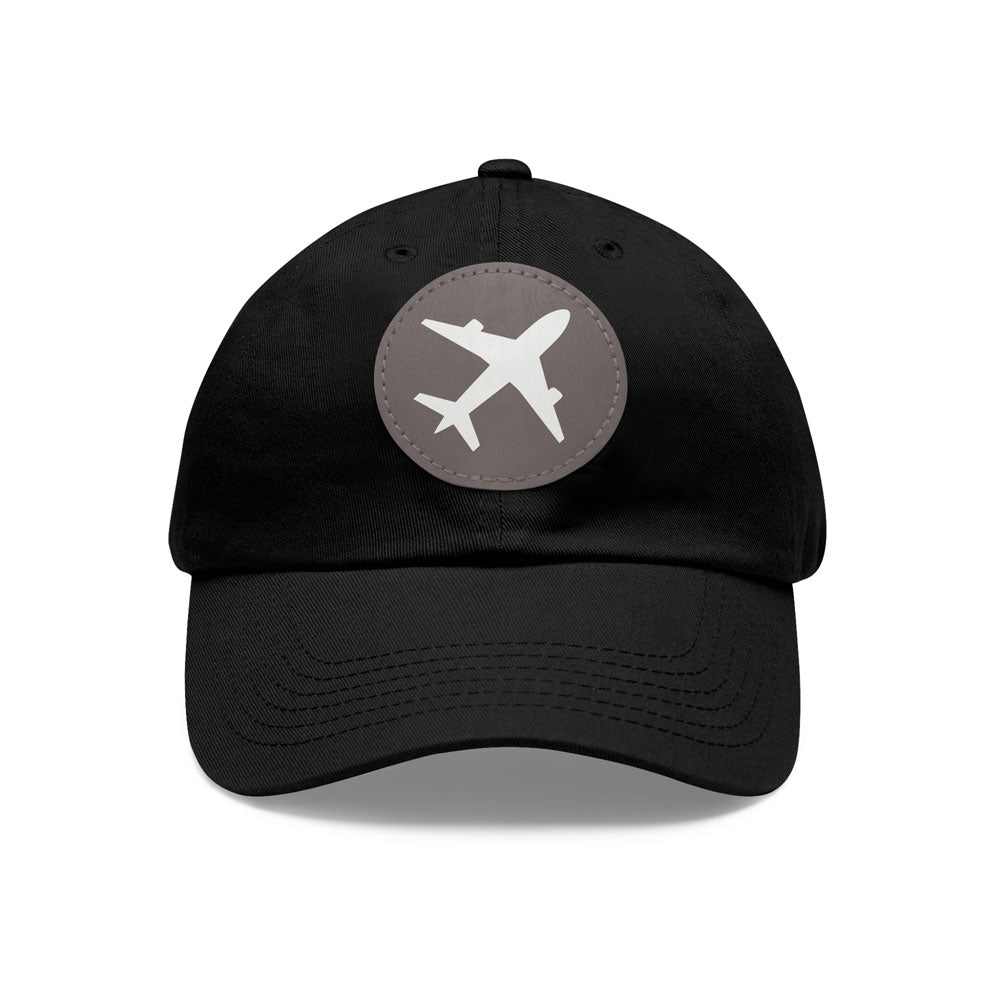 Stylish black twill cotton baseball cap with a round gray leather patch showcasing an airplane emblem, on a white background