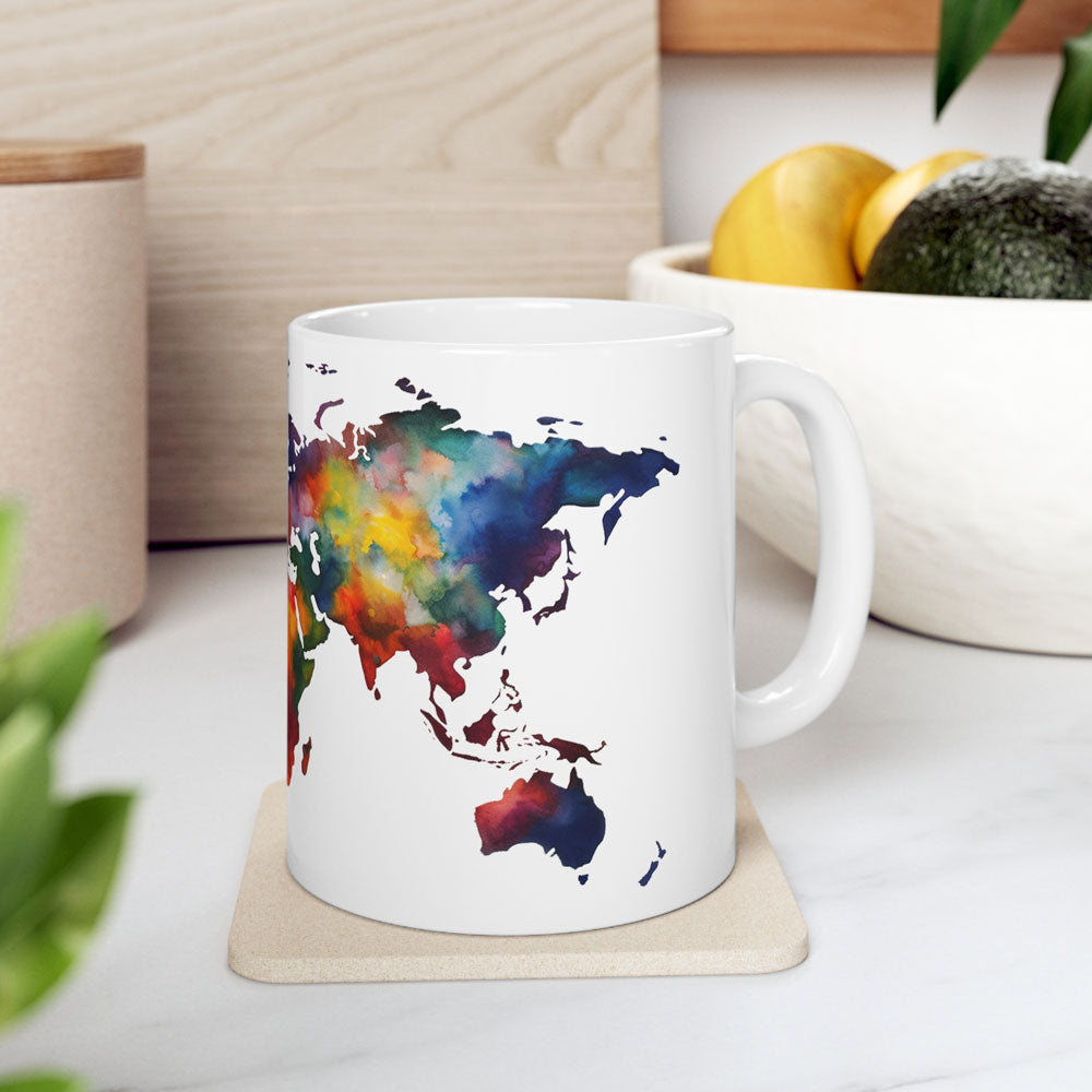 white ceramic coffee mug featuring a color world map, on a table with white cloth and other decoration