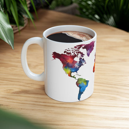 White ceramic coffee mug adorned with a vibrant world map design, resting on a rustic wooden table surrounded by lush green plant decor