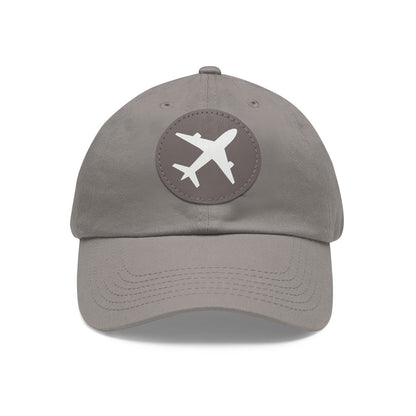 Chic gray twill cotton baseball cap with a round gray leather patch showcasing an airplane emblem, on a white background