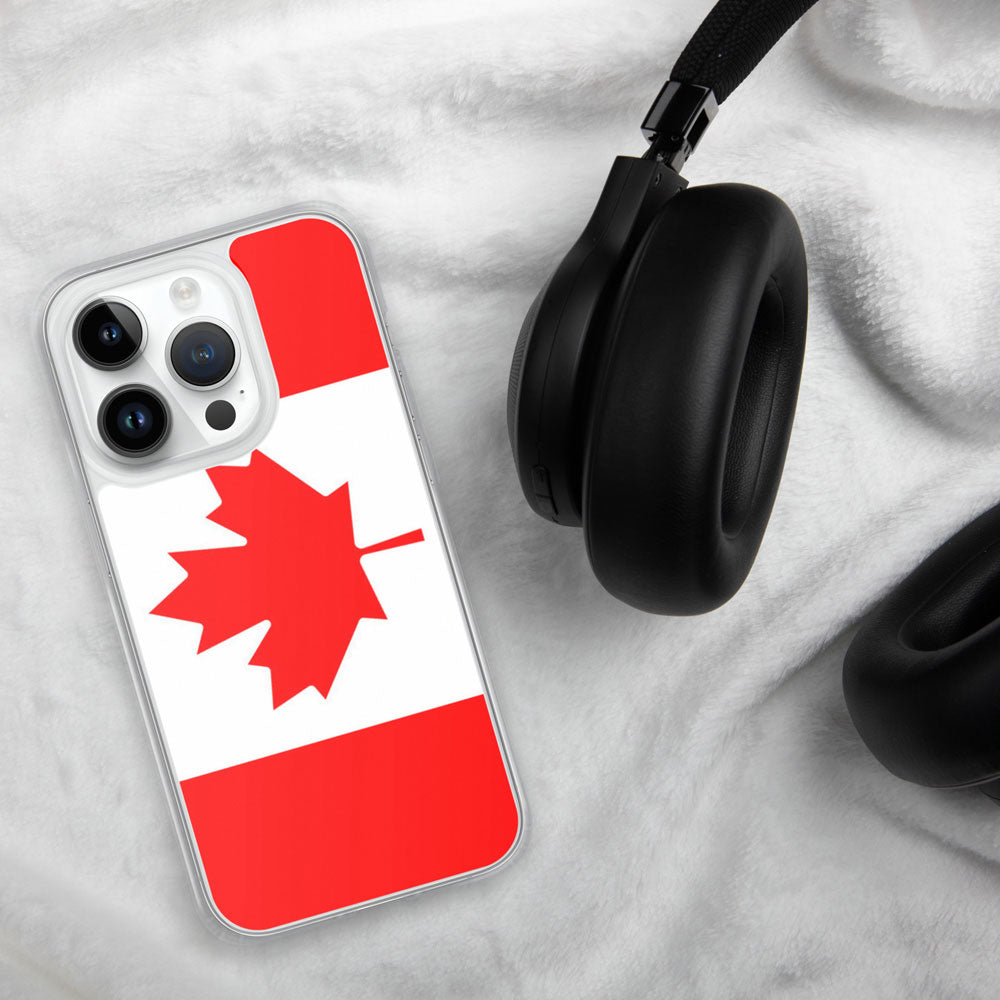 iPhone with a case featuring the Canadian flag on a white linen background with a black headphone