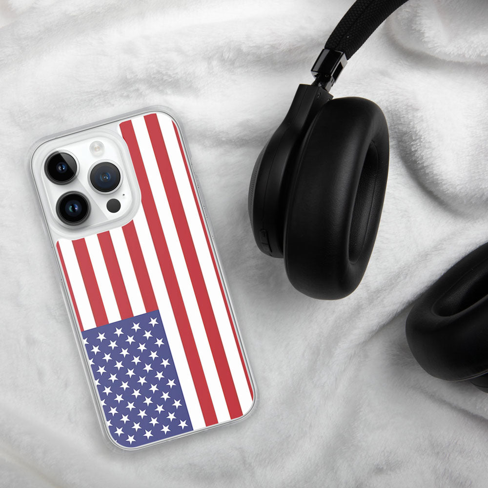 iPhone with a case featuring the United States flag on a white linen background with a black headphone