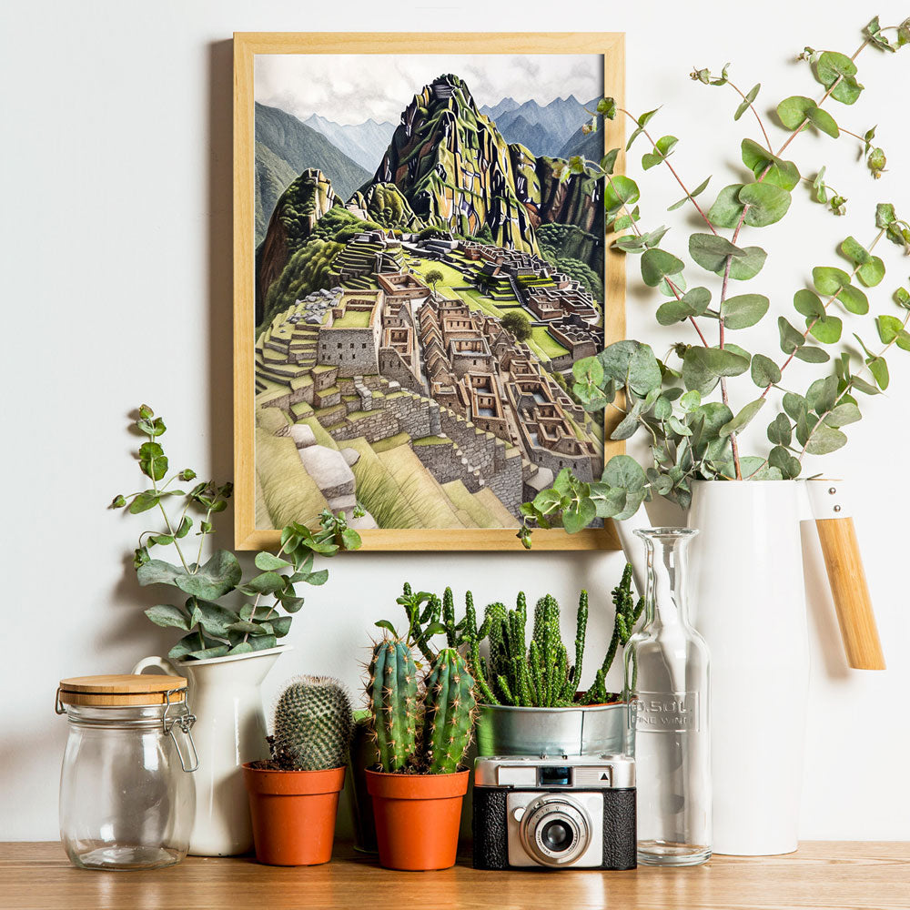 Wood-framed poster of Machu Picchu in Peru on a light wall, above a shelf with vintage camera and plant decor